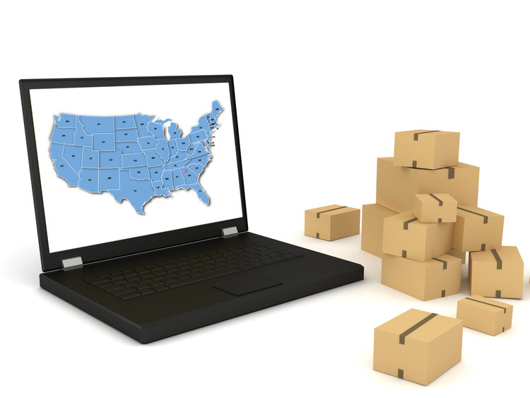 Laptop with the U.S.A. map showing national network of EcoCourier Global Delivery and parcel packages beside it