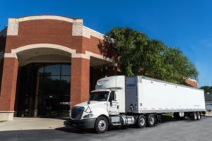Semi-truck parked in front of EcoCourier Global Delivery corporate building